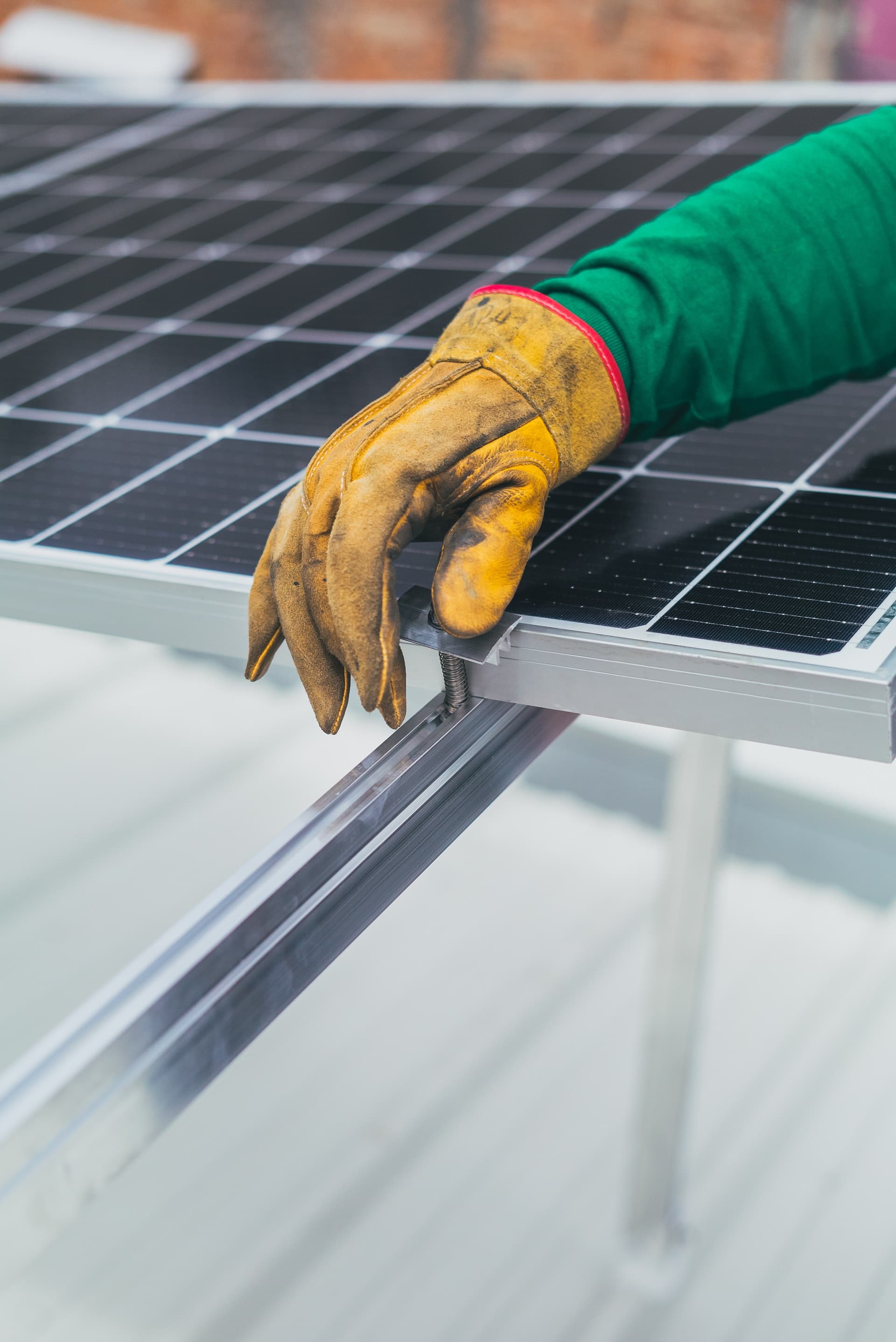 A hand installing a solar panel